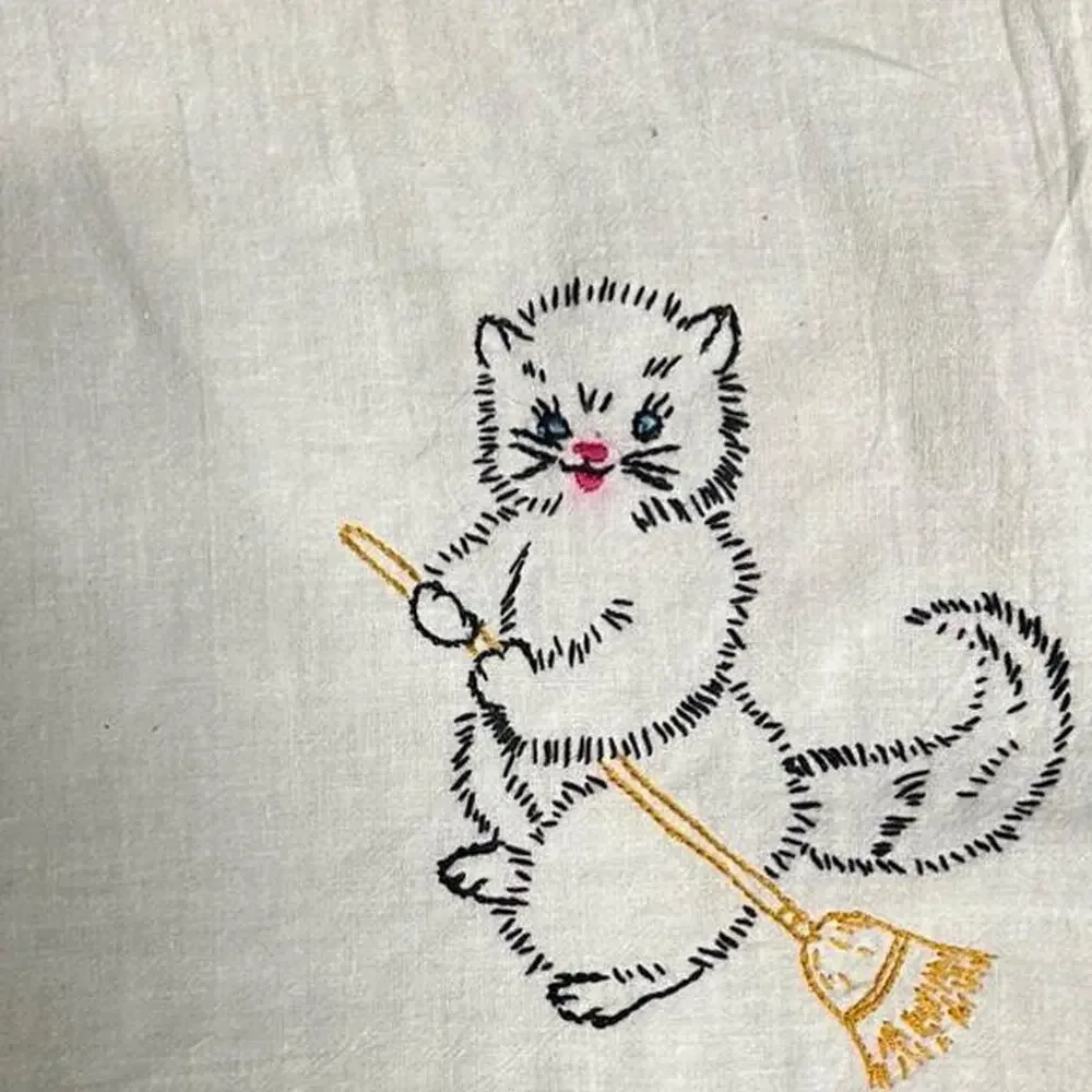 Hand embroidered thin linen hand towel or small tablecloth with a cat and broom